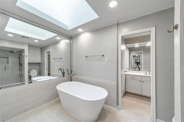 a bathroom with a white tub a sink and mirror
