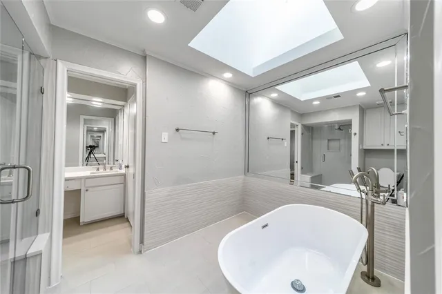 a bathroom with a bathtub shower sink and mirror