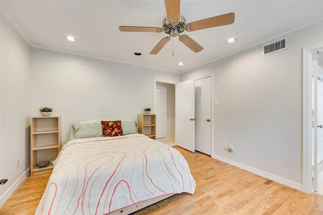 a bedroom with a large bed and a ceiling fan