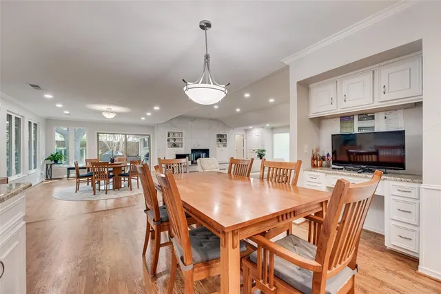 a dining room with furniture a chandelier and wooden floor