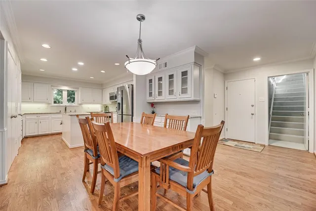 a view of a dining room and livingroom with furniture wooden floor a chandelier