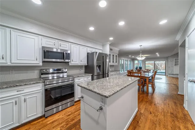 a kitchen with stainless steel appliances granite countertop wooden cabinets a stove top oven a sink and dishwasher