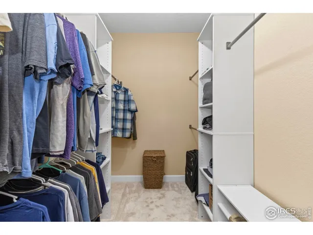 a view of walk in closet with clothes and shoes