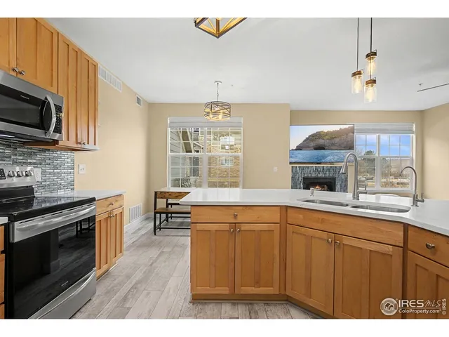a kitchen with stainless steel appliances granite countertop a stove a sink and a microwave