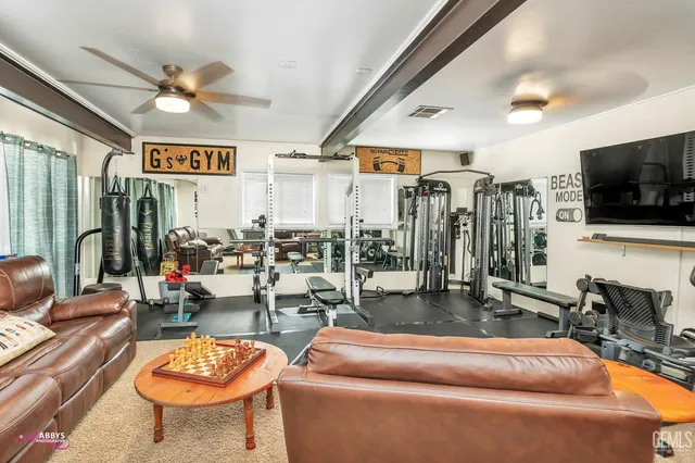 a living room with furniture kitchen view and a chandelier