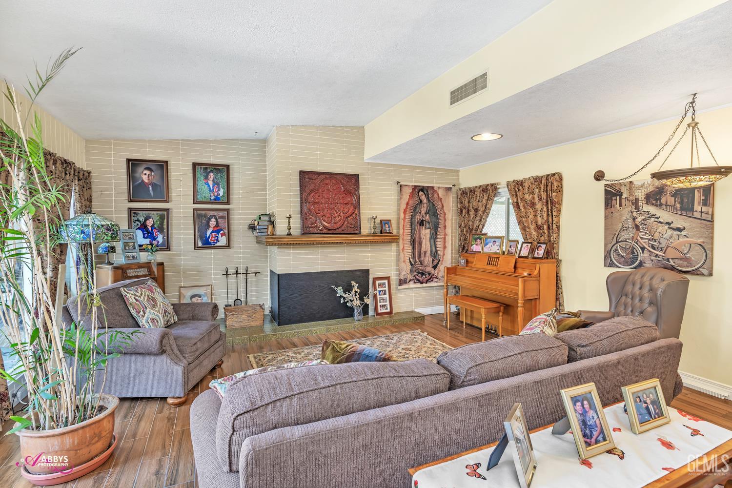 Undisclosed Address Bakersfield, CA 93306 - Photo 23 of 56 a living room with furniture a fireplace and a flat screen tv