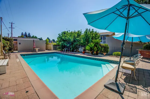 a view of a backyard with potted plants and large trees
