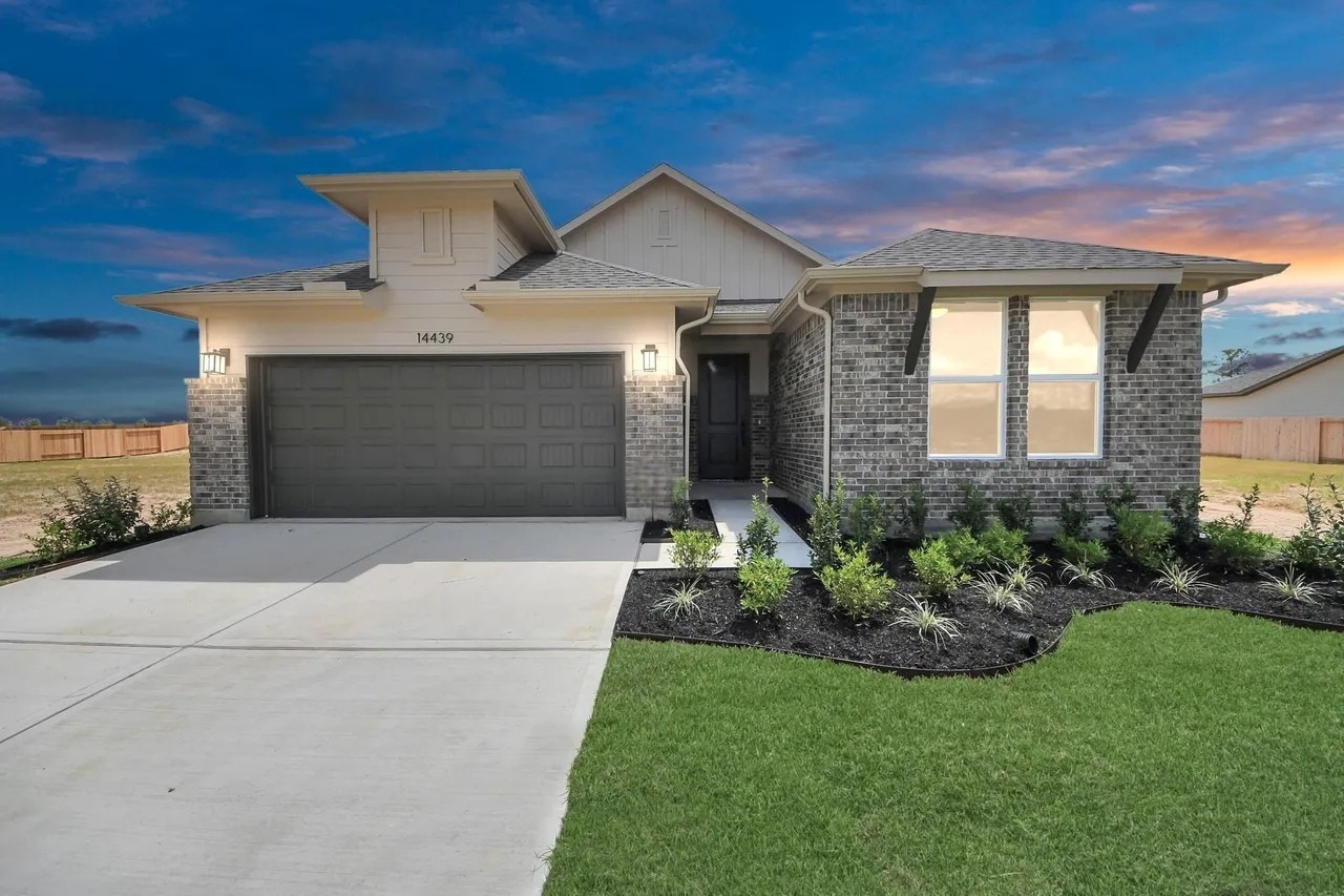 14439 Trumpet Lane Splendora, TX 77372 - Photo 1 of 15 a front view of a house with a garden and garage