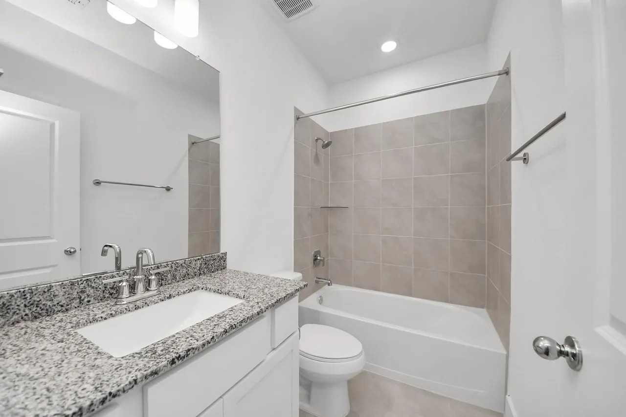 14439 Trumpet Lane Splendora, TX 77372 - Photo 12 of 15 a bathroom with a granite countertop sink a toilet and shower