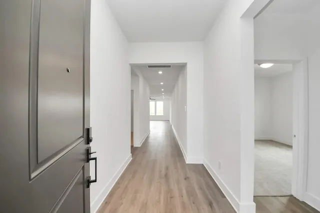 a view of a hallway with wooden floor