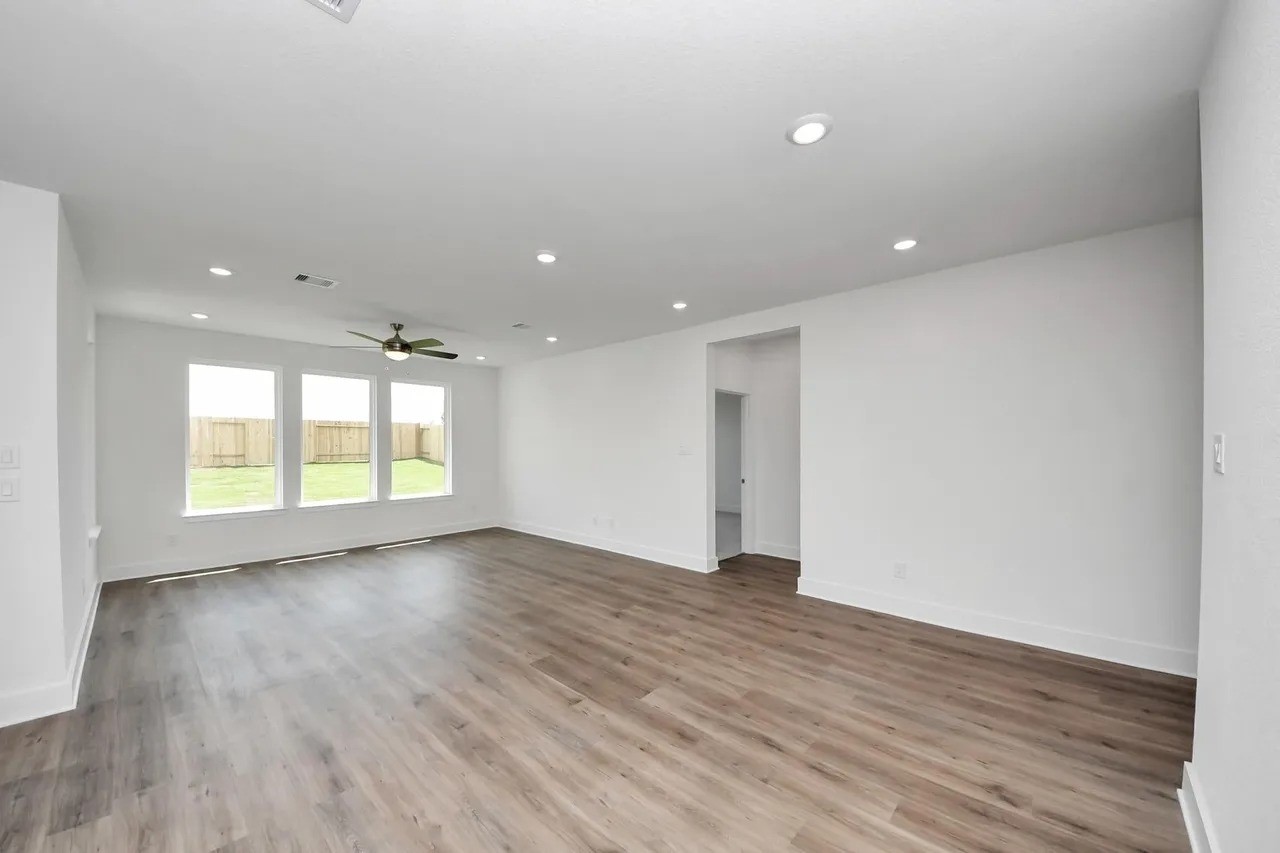 14439 Trumpet Lane Splendora, TX 77372 - Photo 6 of 15 an empty room with wooden floor and windows