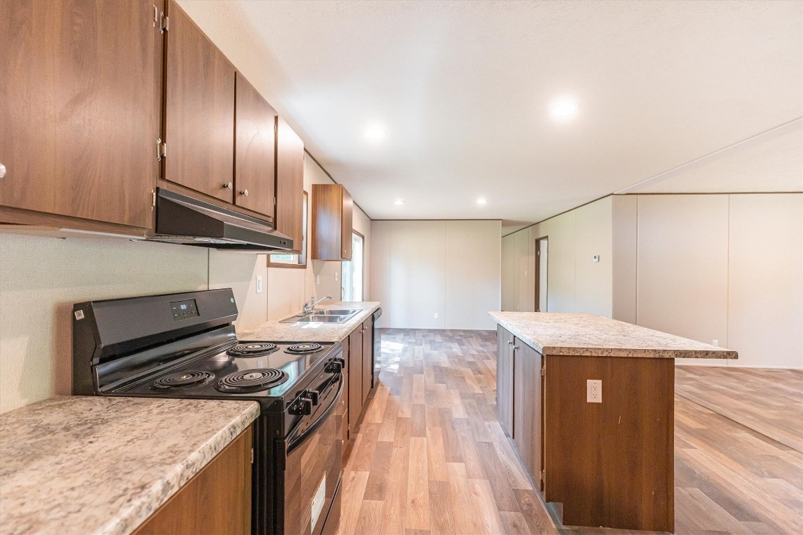 16465 Hickory Road Conroe, TX 77302 - Photo 22 of 42 a kitchen that has a sink a stove top oven a counter space and cabinets