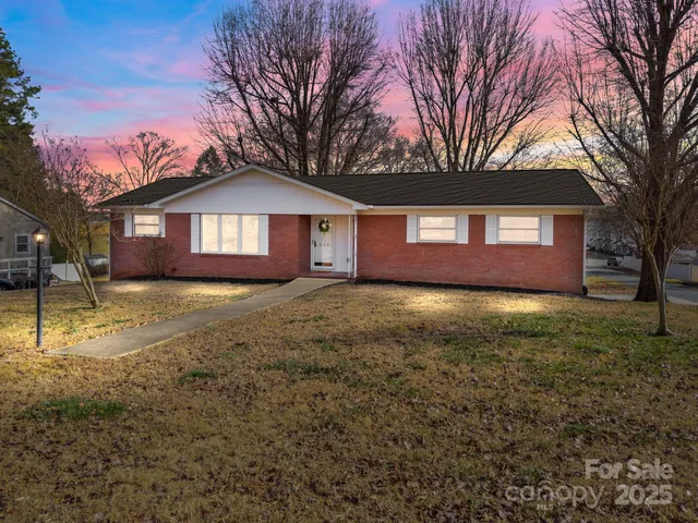 a front view of a house with a yard and trees