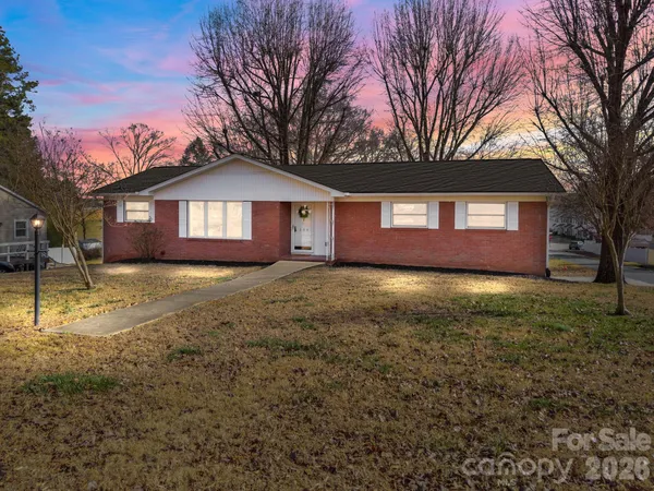 a front view of a house with a yard and trees