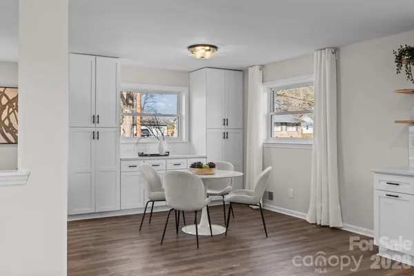 a view of a dining room with furniture a chandelier and wooden floor