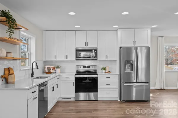 a kitchen with stainless steel appliances a refrigerator sink and cabinets