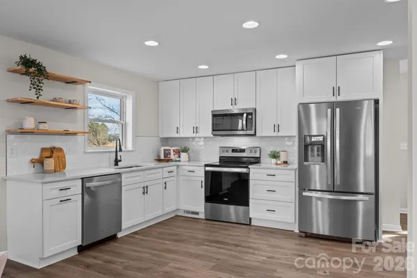 a kitchen with stainless steel appliances a refrigerator sink and microwave
