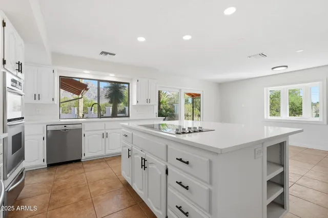 a kitchen with a stove a sink a counter space and windows
