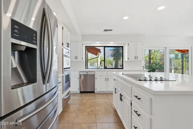 a large white kitchen with a stove a sink a microwave and a refrigerator