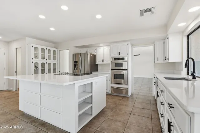 a kitchen with stainless steel appliances a stove refrigerator sink and cabinets