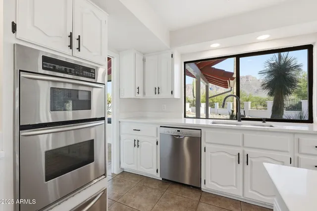 a kitchen with white cabinets and white appliances