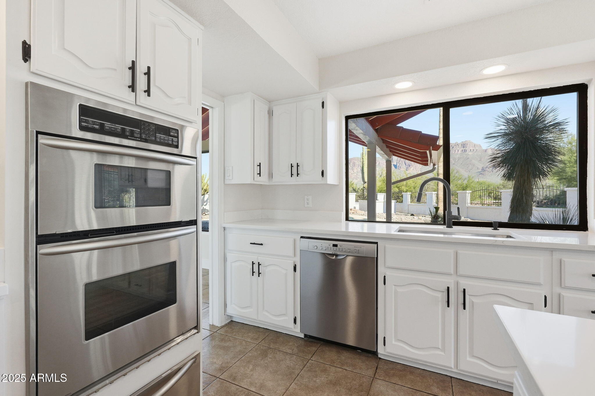 5810 East 14th Avenue Apache Junction, AZ 85119 - Photo 19 of 38 a kitchen with white cabinets and white appliances