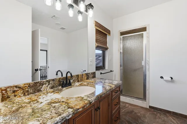 a bathroom with a granite countertop sink and a mirror