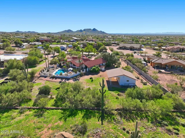 an aerial view of residential houses with outdoor space and trees
