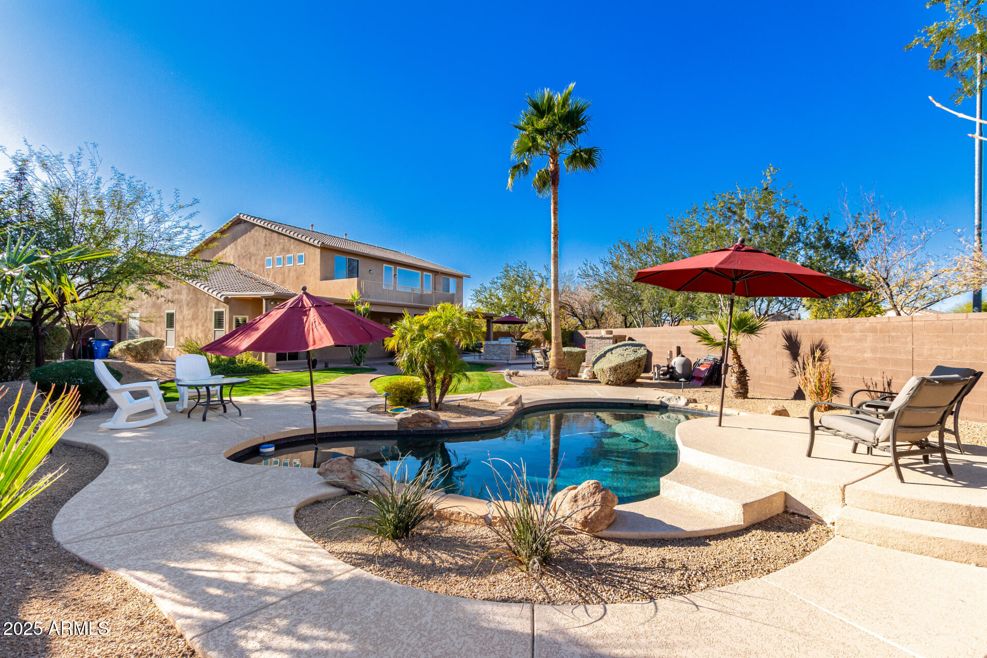 5902 West Gambit Trail Phoenix, AZ 85083 - Photo 2 of 62 a view of a backyard with a table and chairs under an umbrella