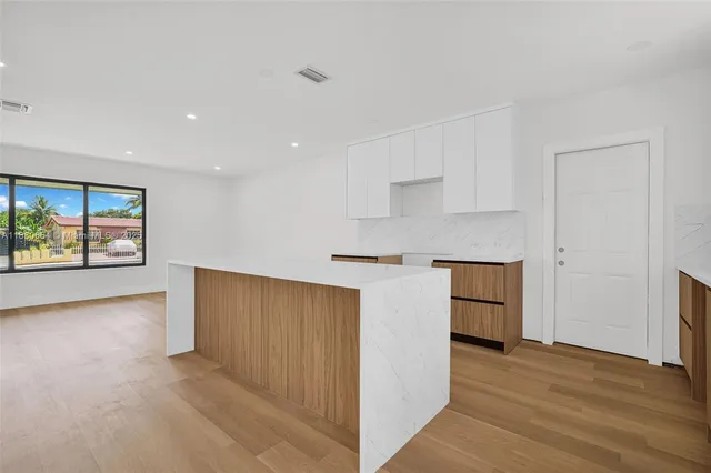 a view of kitchen with wooden floor and electronic appliances