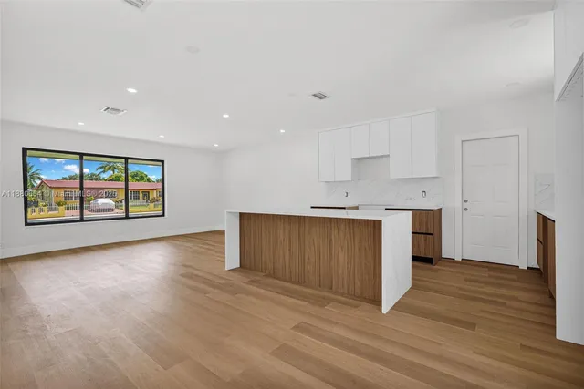 a view of kitchen with wooden floor electronic appliances and window