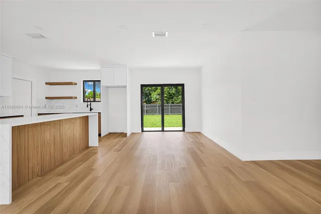 a view of a kitchen with wooden floor and electronic appliances