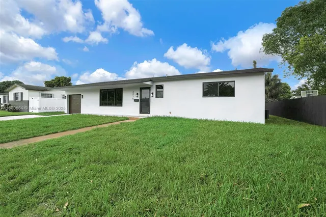 a front view of house with yard and trees