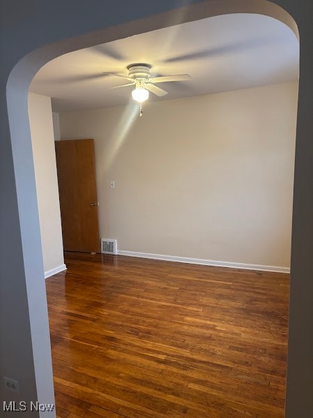 1019 Quilliams Road Cleveland Heights, OH 44121 - Photo 19 of 32 Spare room featuring arched walkways, dark wood-type flooring, and ceiling fan