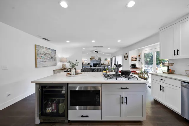 a kitchen that has a lot of cabinets a sink and appliances in it