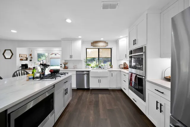 a kitchen with stainless steel appliances white cabinets and a refrigerator