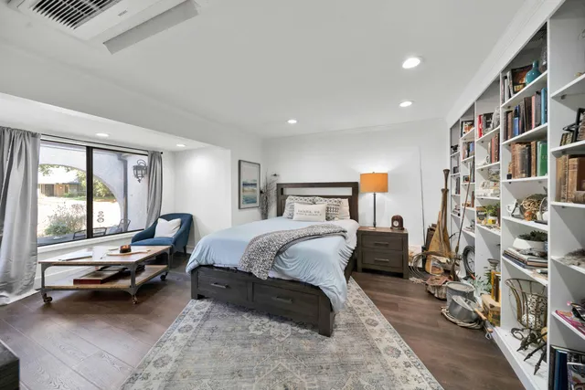 a large bedroom with a bed and flat screen tv