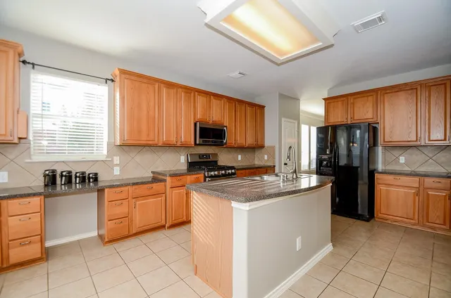 a kitchen with stainless steel appliances granite countertop a stove sink microwave and cabinets