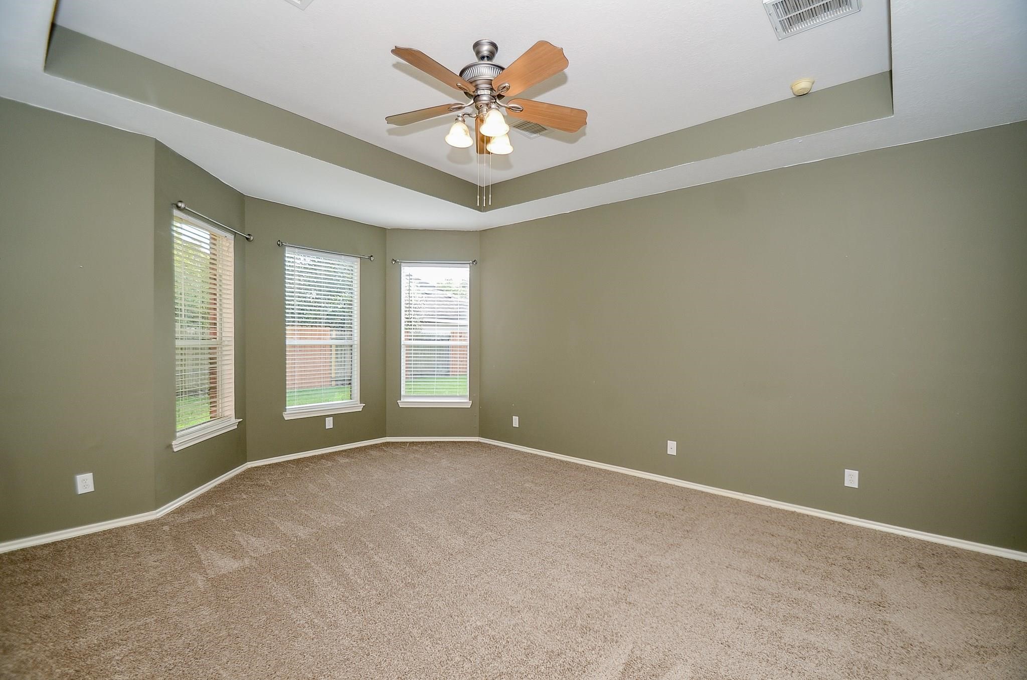 23719 Tustin Ranch Court Katy, TX 77494 - Photo 17 of 31 an empty room with windows and ceiling fan