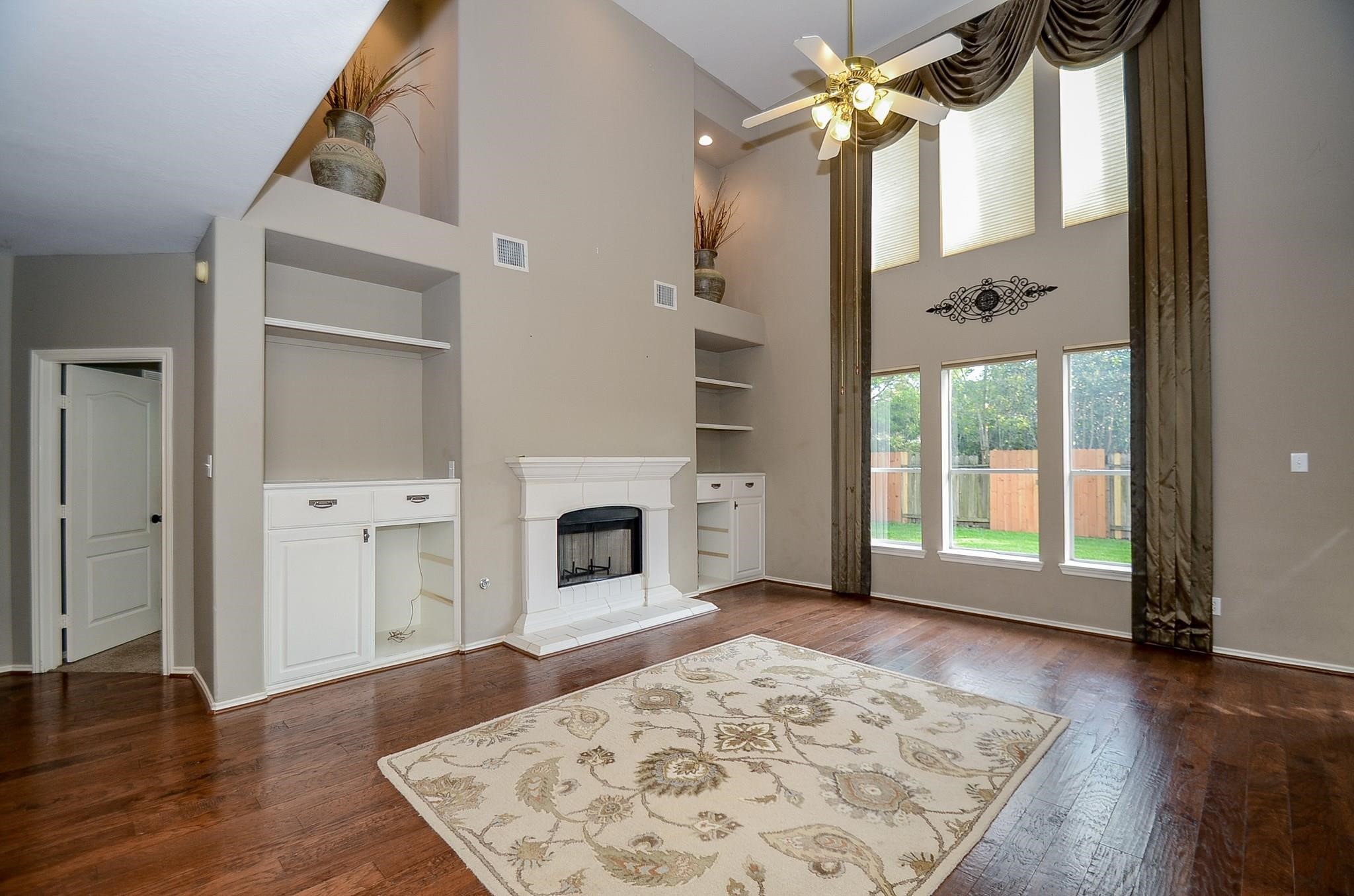 23719 Tustin Ranch Court Katy, TX 77494 - Photo 2 of 31 a view of a livingroom with wooden floor a fireplace and windows