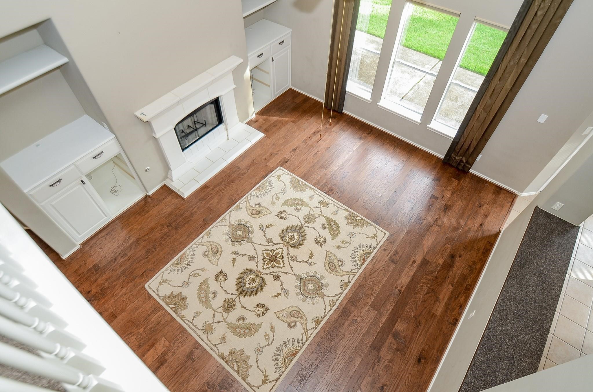 23719 Tustin Ranch Court Katy, TX 77494 - Photo 3 of 31 a view of an empty room with wooden floor and a fireplace