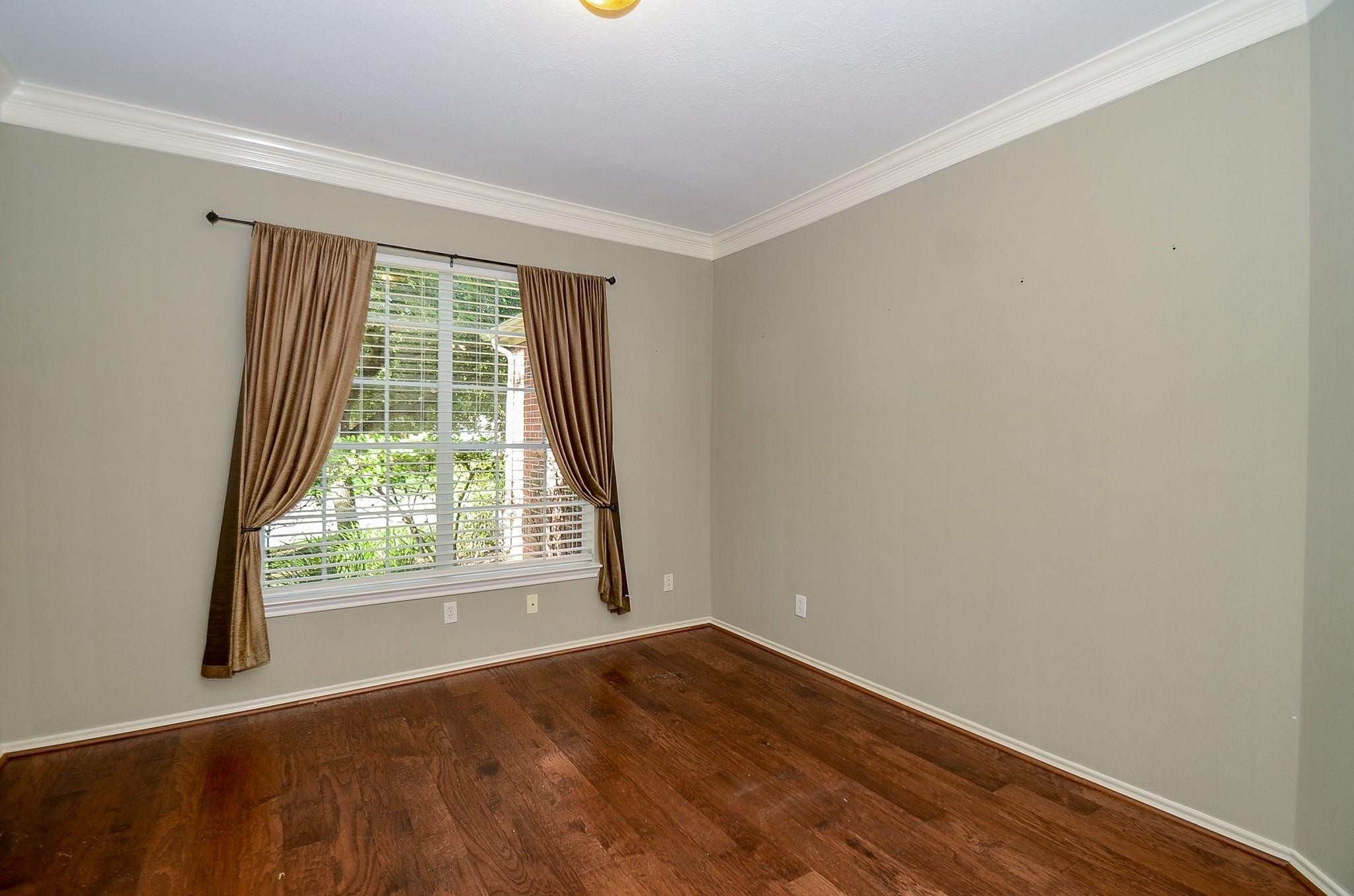23719 Tustin Ranch Court Katy, TX 77494 - Photo 7 of 31 an empty room with wooden floor and windows
