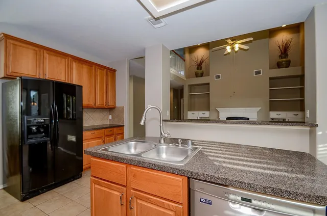 a kitchen with stainless steel appliances granite countertop a sink and a refrigerator
