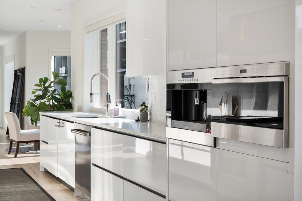 100 A Street, Unit 4 Boston, MA 02127 - Photo 13 of 42 a kitchen with stainless steel appliances a sink and cabinets