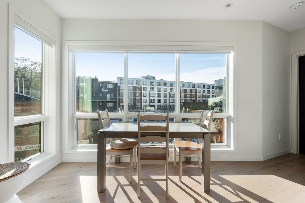 100 A Street, Unit 4 Boston, MA 02127 - Photo 14 of 42 a dining room with furniture a fireplace and wooden floor