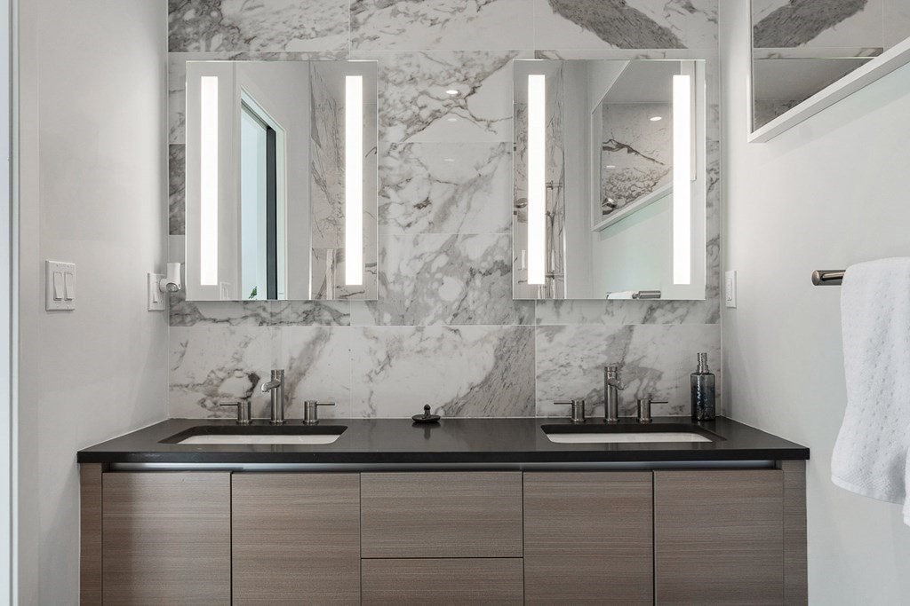 100 A Street, Unit 4 Boston, MA 02127 - Photo 30 of 42 a bathroom with a granite countertop sink a mirror and cabinets