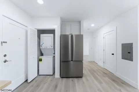 a kitchen with a refrigerator and wooden floor