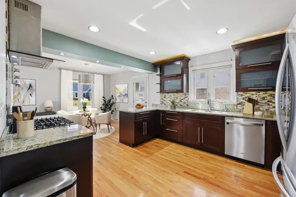 a large kitchen with stainless steel appliances kitchen island granite countertop a sink dishwasher stove and cabinets