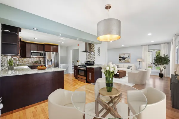 a living room with furniture kitchen view and a chandelier