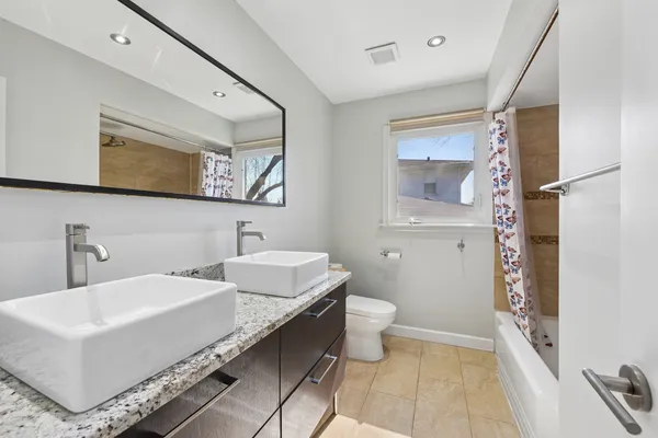 a bathroom with a double vanity sink mirror and toilet